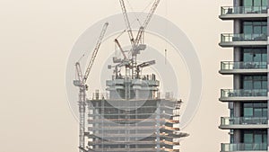 Skyscraper under construction with cranes and iron frame timelapse