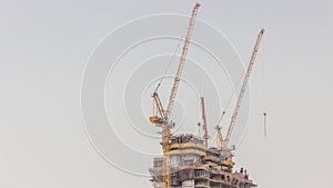 Skyscraper under construction with cranes and iron frame timelapse