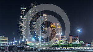 Skyscrapers of Abu Dhabi at night with Etihad Towers buildings .