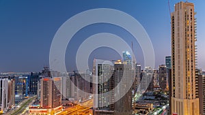 Skyscrapers at the Business Bay in Dubai aerial day to night timelapse, United Arab Emirates