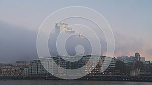 Skyscrapers in City of London with the buildings in mist in the business area on a misty morning of