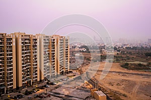 Skyscrapers in gurgaon looking out over barren land and a village