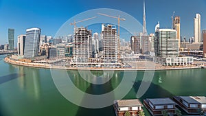 Skyscrapers near canal in Dubai with blue sky aerial timelapse