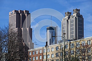 Skyscrapers and office buildings in the city skyline with bare winter trees and a gorgeous blue sky with clouds in Atlanta Georgia