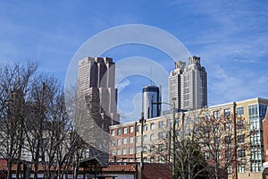 Skyscrapers and office buildings in the city skyline with bare winter trees and a gorgeous blue sky with clouds in Atlanta Georgia