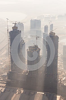 Skyscrappers construction site with cranes on top of buildings.