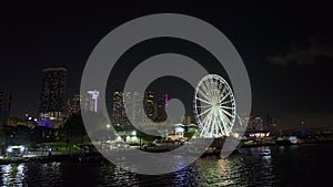 Skyviews Miami Observation Wheel at Bayside Marketplace with reflections in Biscayne Bay water and high illuminated