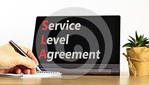 SLA service level agreement symbol. Concept words SLA service level agreement on beautiful black tablet. Beautiful white