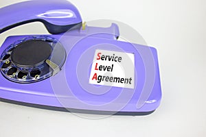 SLA service level agreement symbol. Concept words SLA service level agreement on beautiful old disk phone. Beautiful white