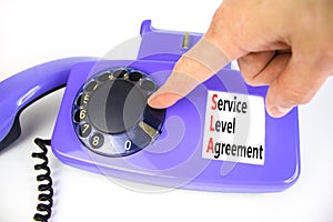 SLA service level agreement symbol. Concept words SLA service level agreement on beautiful old disk phone. Beautiful white