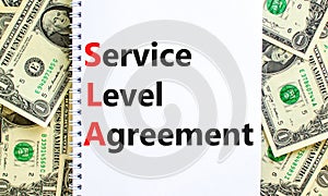 SLA service level agreement symbol. Concept words SLA service level agreement on beautiful white note. Beautiful dollar bills