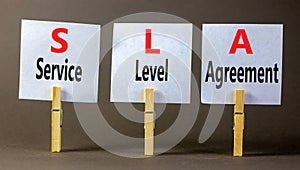 SLA service level agreement symbol. Concept words SLA service level agreement on beautiful white paper. Beautiful grey background