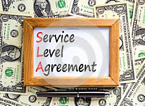 SLA service level agreement symbol. Concept words SLA service level agreement on beautiful wooden frame. Beautiful dollar bills