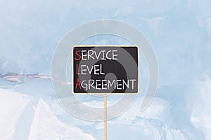 SLA service level agreement symbol. Concept words SLA service level agreement on beautiful yellow blackboard. Beautiful blue ice
