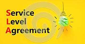 SLA service level agreement symbol. Concept words SLA service level agreement on beautiful yellow paper. Beautiful yellow paper