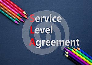 SLA service level agreement symbol. Concept words SLA service level agreement on black paper. Beautiful black background. Colored