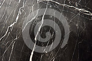 A slab of natural marble, black with white stripes veins, called Nero Marquina photo