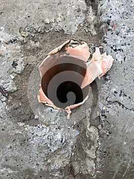 Slabs of concrete has an opening for a clay pipe
