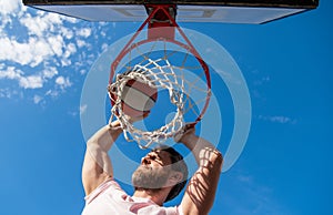 slam dunk in motion. summer activity. jumping man with basketball ball on court.