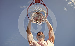 slam dunk in motion. summer activity. winning man with basketball ball on court.