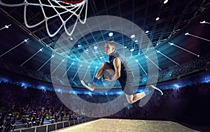 Slam dunk. Young man, professional basketball player on 3D stadium, arena during game, jumping with ball