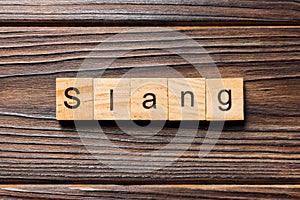 Slang word written on wood block. slang text on table, concept photo