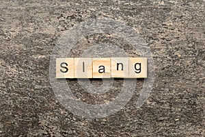 slang word written on wood block. slang text on table, concept photo