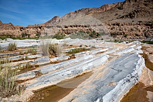 Slanted limestone benches in front of mountain range in Oman`s Wadi al-Arbaeen