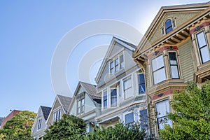 Slanted low angle view of houses with decorative shingles and bay windows at San Francisco, CA