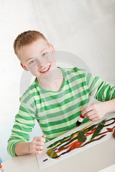 Slanted view of smiling boy with paint brush