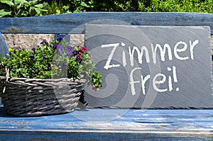 Slate on a garden bench with the german words for vacancies - zimmer frei