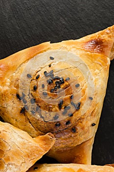 Slate plate with delicious samosas on grey background