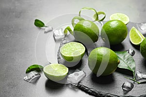 Slate plate with fresh ripe limes and ice cubes
