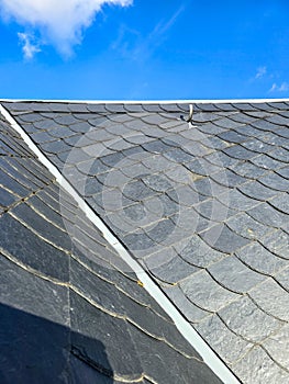 Slate or schist tiled roofing and blue sky