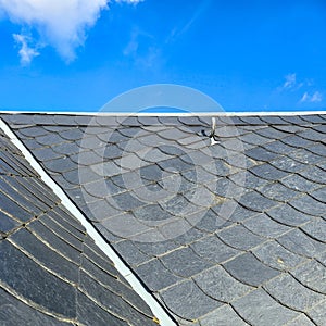 Slate or schist tiled roofing and blue sky