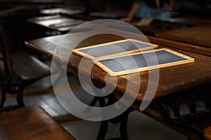 Slates on Wooden Desk Schoolteacher in Background