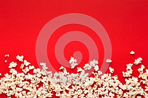 Slaty popcorn scattered on red background, top view