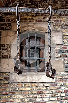 Slavery and bondage strong steel old shackles on bricks background