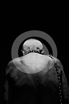 Slavery. A man tied with a chain over his neck.