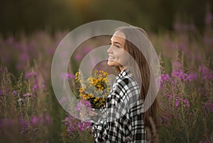 Slavian girl with wild flowers on the field