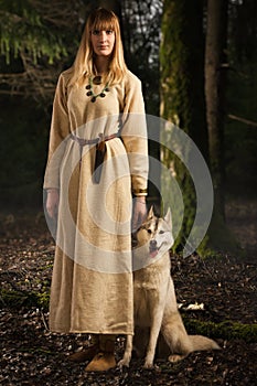 Slavonian girl and siberian husky in the deep forest