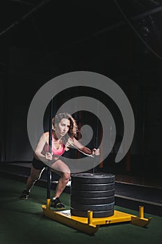 Sled push woman pushing weights workout exercise