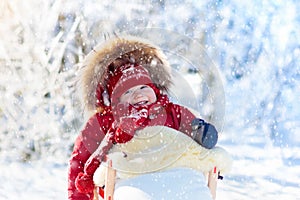 Sled and snow fun for kids. Baby sledding in winter park.