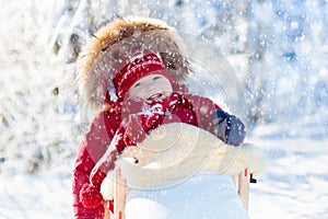 Sled and snow fun for kids. Baby sledding in winter park.