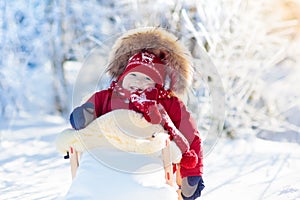 Sled and snow fun for kids. Baby sledding in winter park.