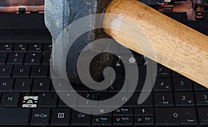 Sledge hammer hitting laptop computer keyboard