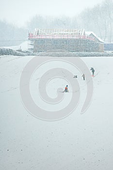 Sledging in a field while snowing