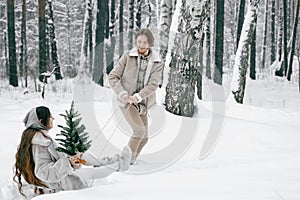 Sledging love romantic young couple girl,guy in snowy winter forest with christmas tree, sled.Walking with sleigh in