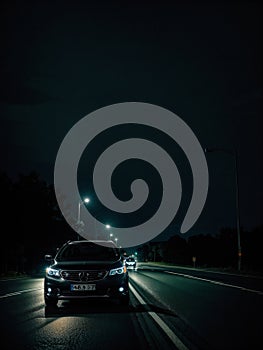 Sleek black car cruising down a dark road on a mysterious and eerie night