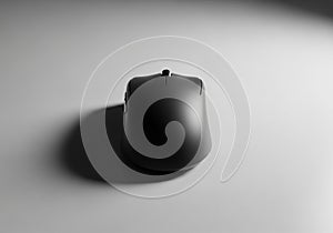 A sleek, black computer mouse is centered on a smooth, gray